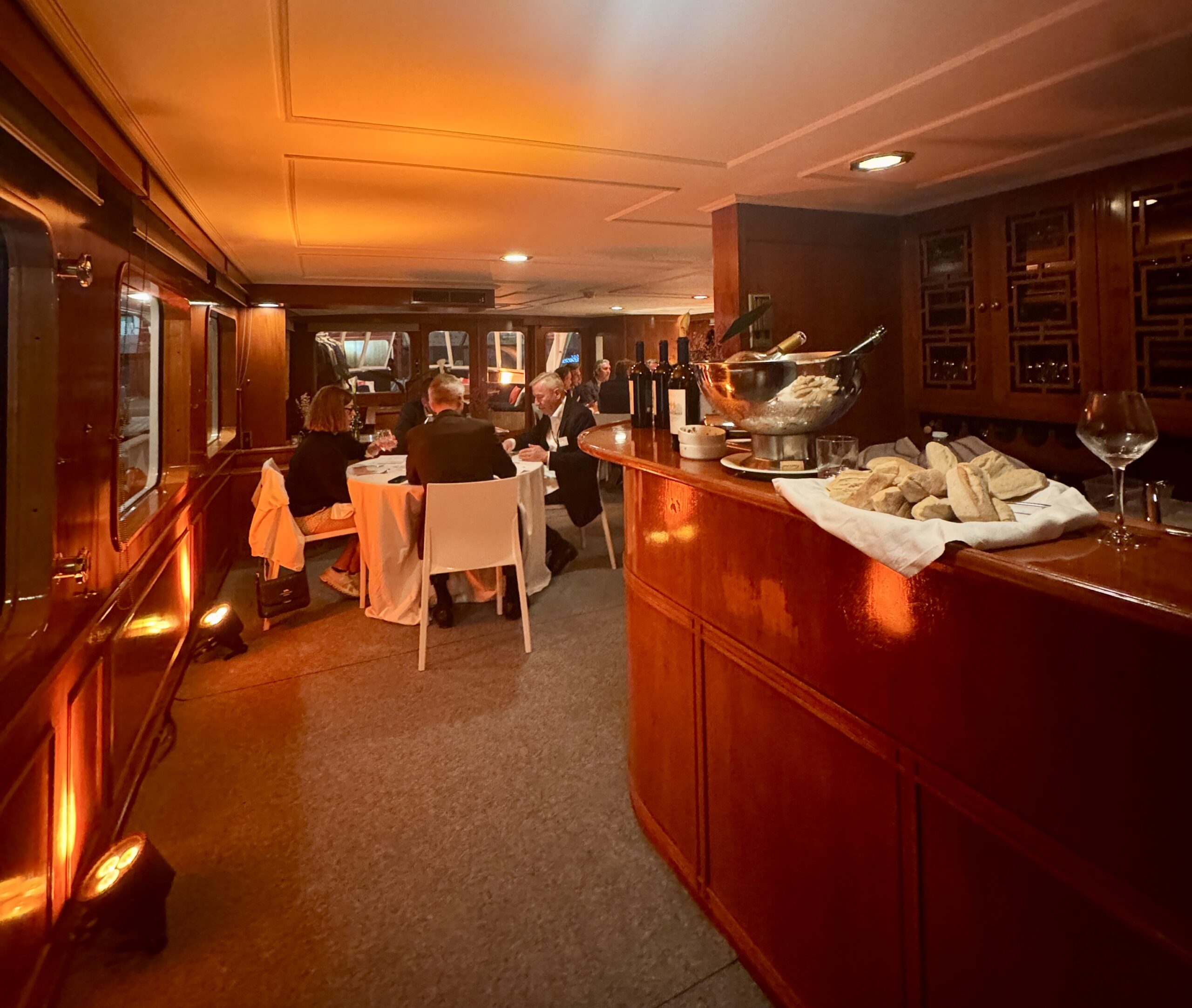 Investor yacht Cannes congress: warm yacht interior set for a confidential dinner during a Palais des Festivals congress